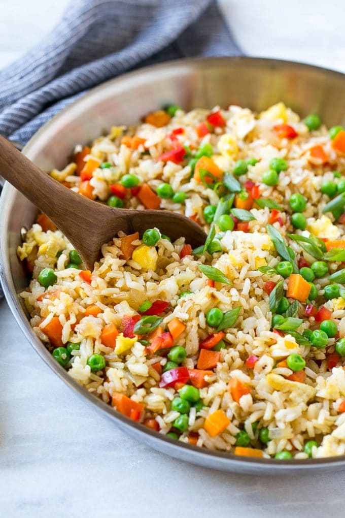 Veggie fried rice in a skillet with a serving spoon.