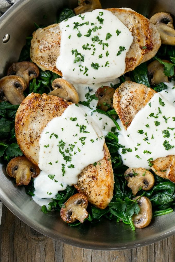 This recipe for chicken florentine is golden brown chicken breasts, topped with a creamy sauce and served over a bed of spinach. A classic dinner that will have you licking your plate!