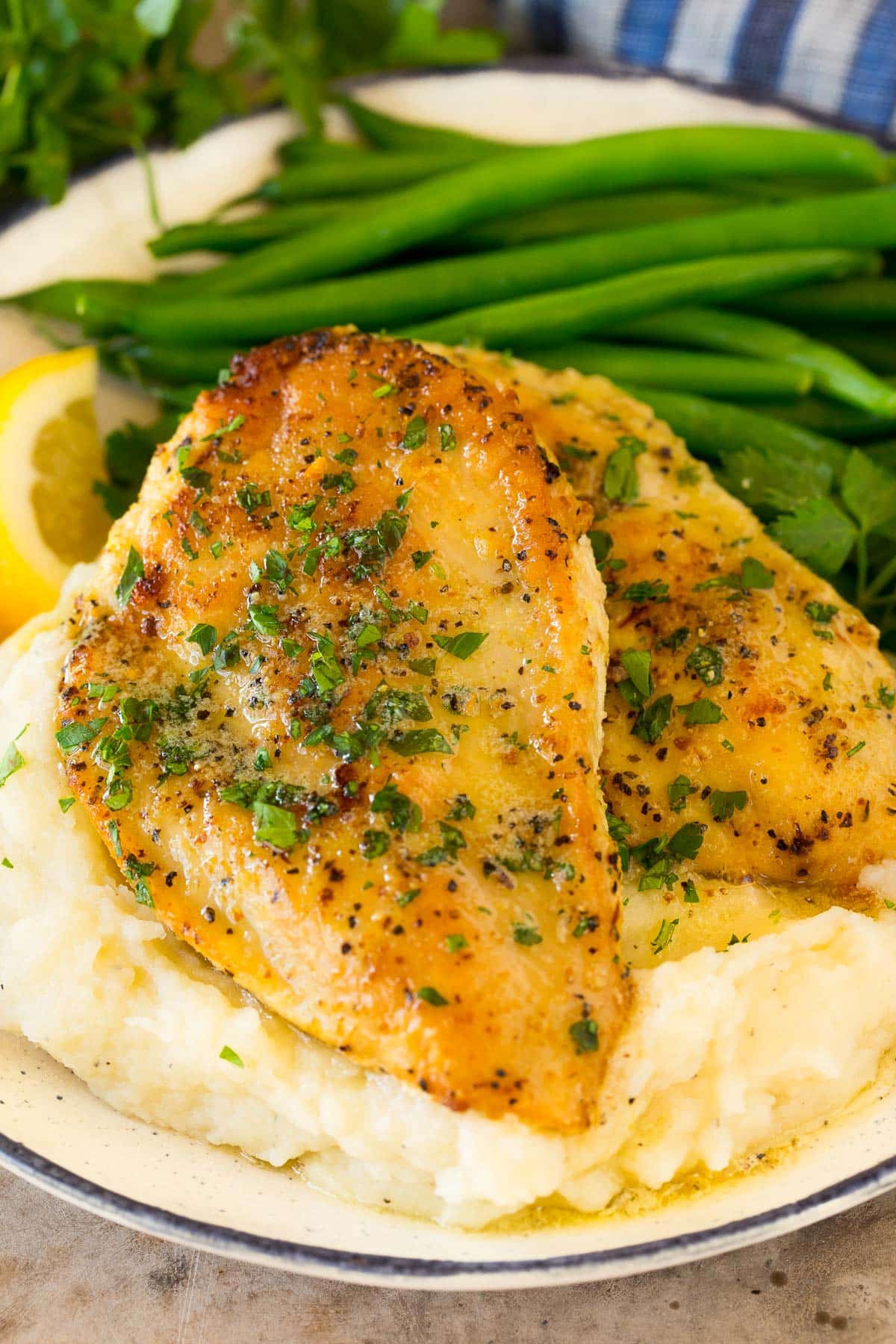 Lemon pepper chicken served with mashed potatoes and green beans.
