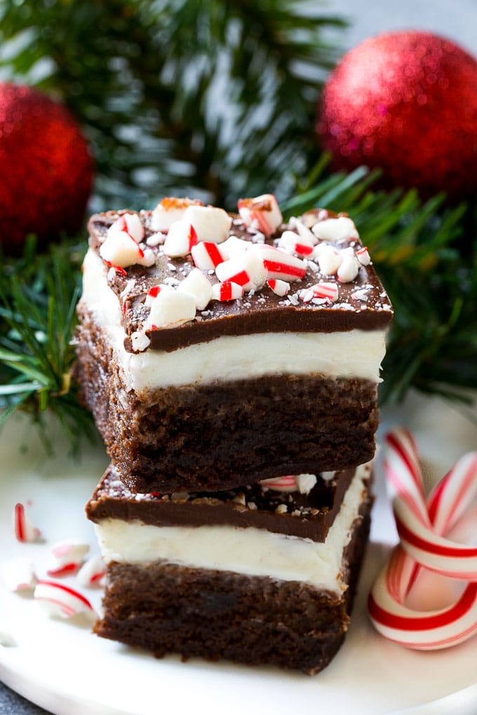 Peppermint Brownies Recipe | Holiday Brownies | Candy Cane Brownies | Mint Brownies #brownies #mint #peppermint #chocolate #dessert #christmas #dinneratthezoo These layered treats on a plate are simple to make yet look so impressive.