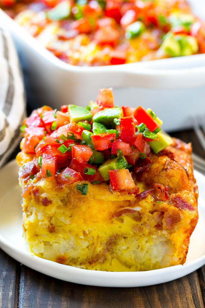 A slice of egg casserole with potato tots in it.