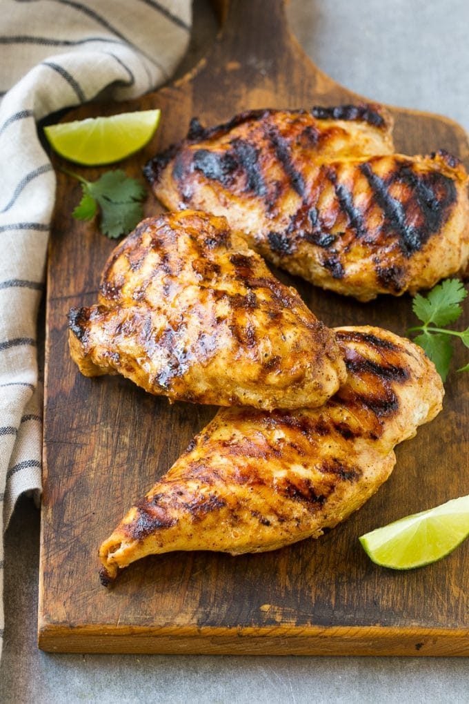 Grilled chicken breasts on a cutting board.