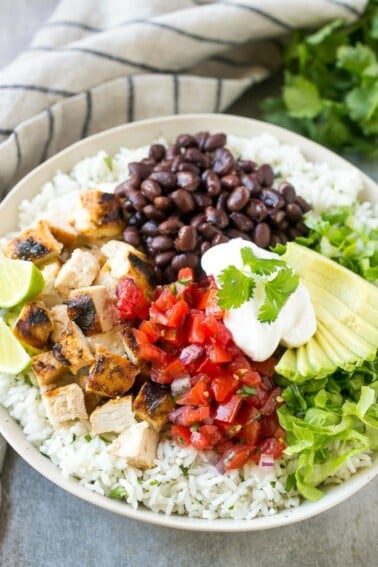 These burrito bowls are loaded with marinated grilled chicken, cilantro lime rice, black beans and a variety of fun toppings. This recipe will become a dinner time staple at your house!