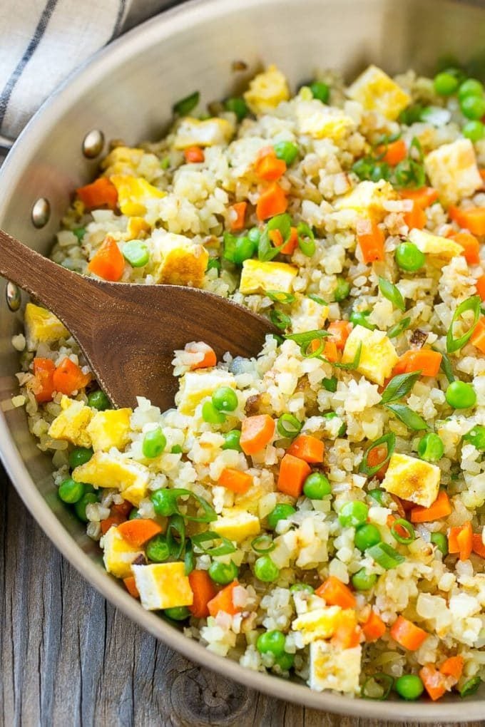 Cauliflower fried rice with eggs, peas and carrots in a skillet.