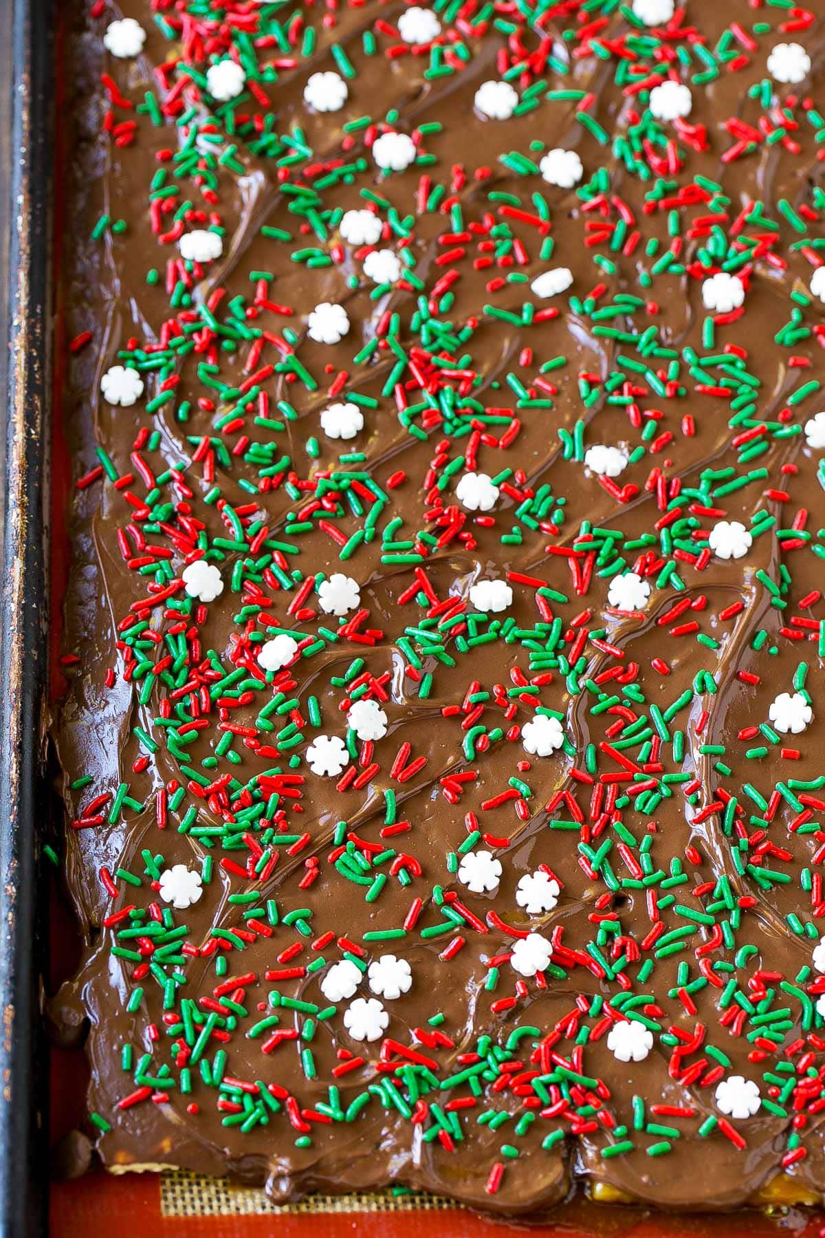 A pan of toffee covered in chocolate and sprinkles.