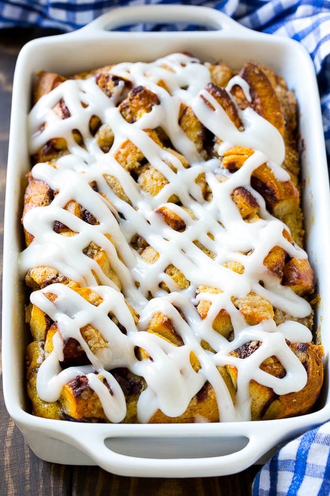 A casserole dish of cinnamon roll french toast with icing poured over the top.