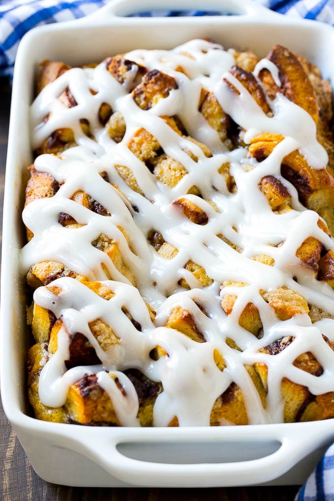 A cinnamon roll french toast casserole in a baking dish, topped with icing.