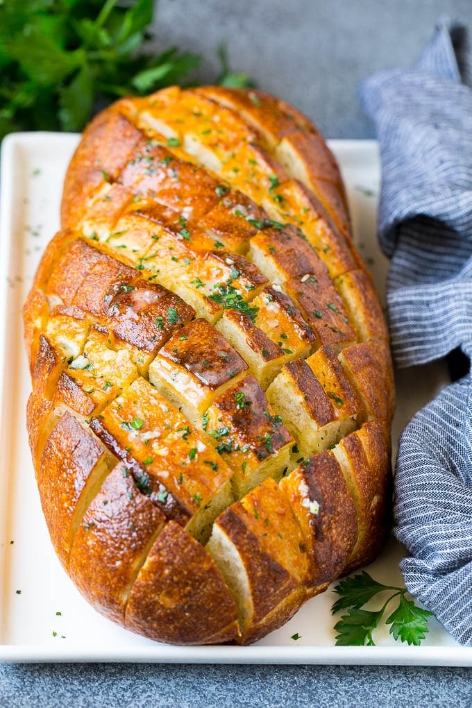 Baked garlic pull apart bread garnished with parsley.