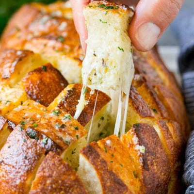 A hand grabbing a piece of pull apart bread.
