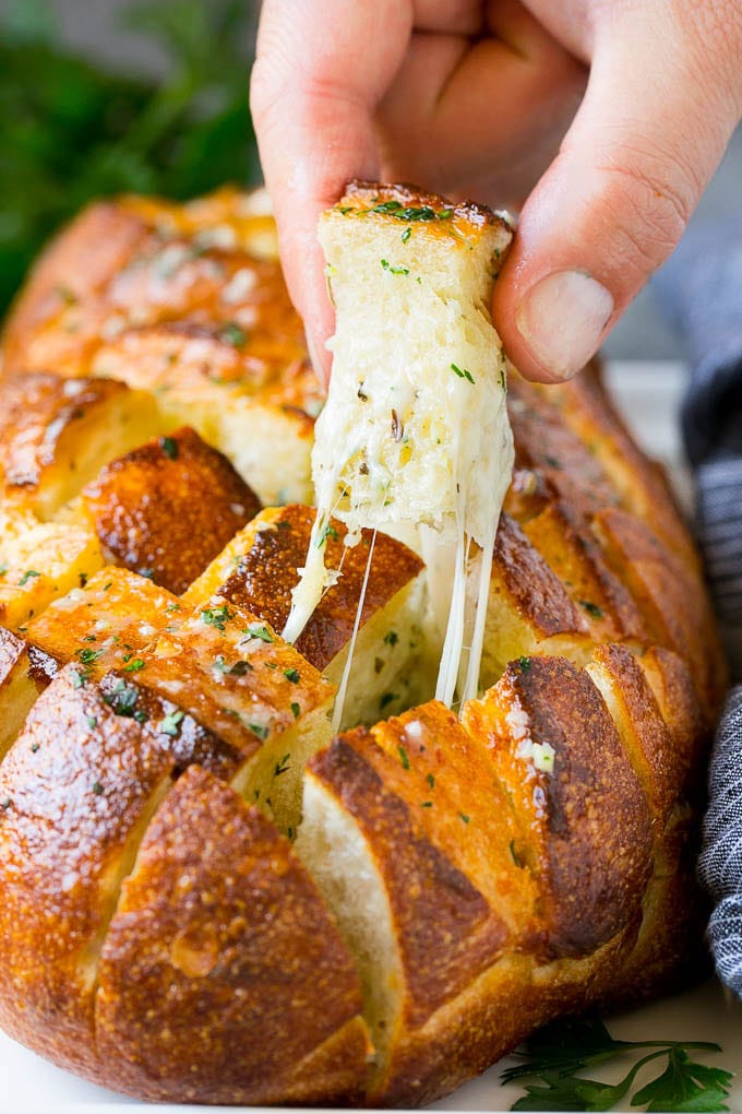 A hand grabbing a piece of pull apart bread.