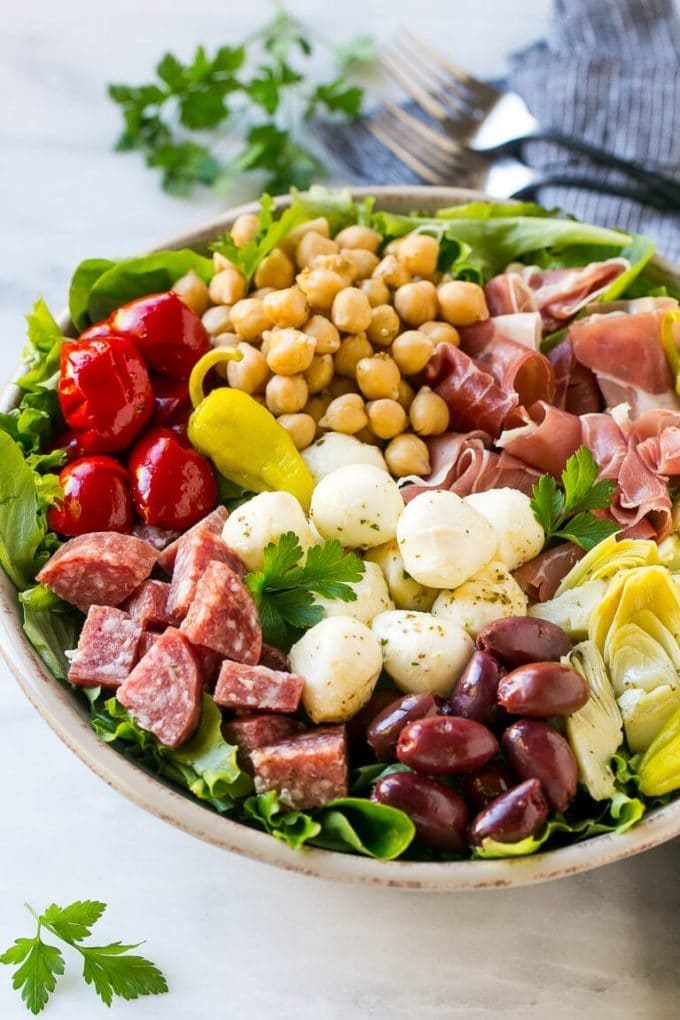 Antipasto salad with cured meats, fresh mozzarella cheese and roasted peppers over salad greens.