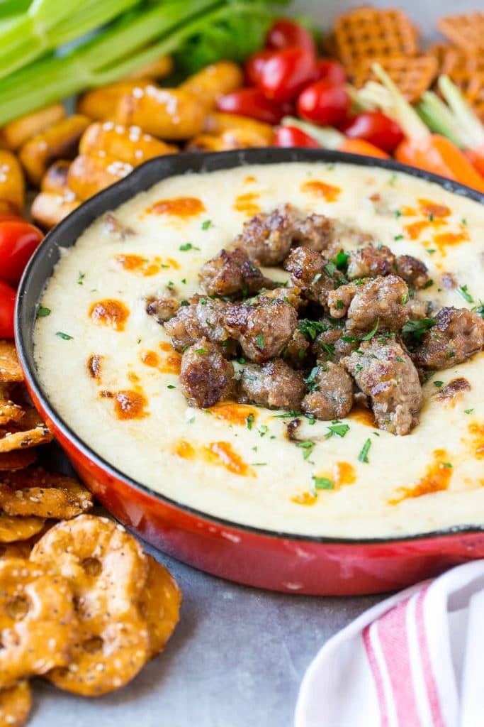 Beer cheese dip topped with sausage and parsley.