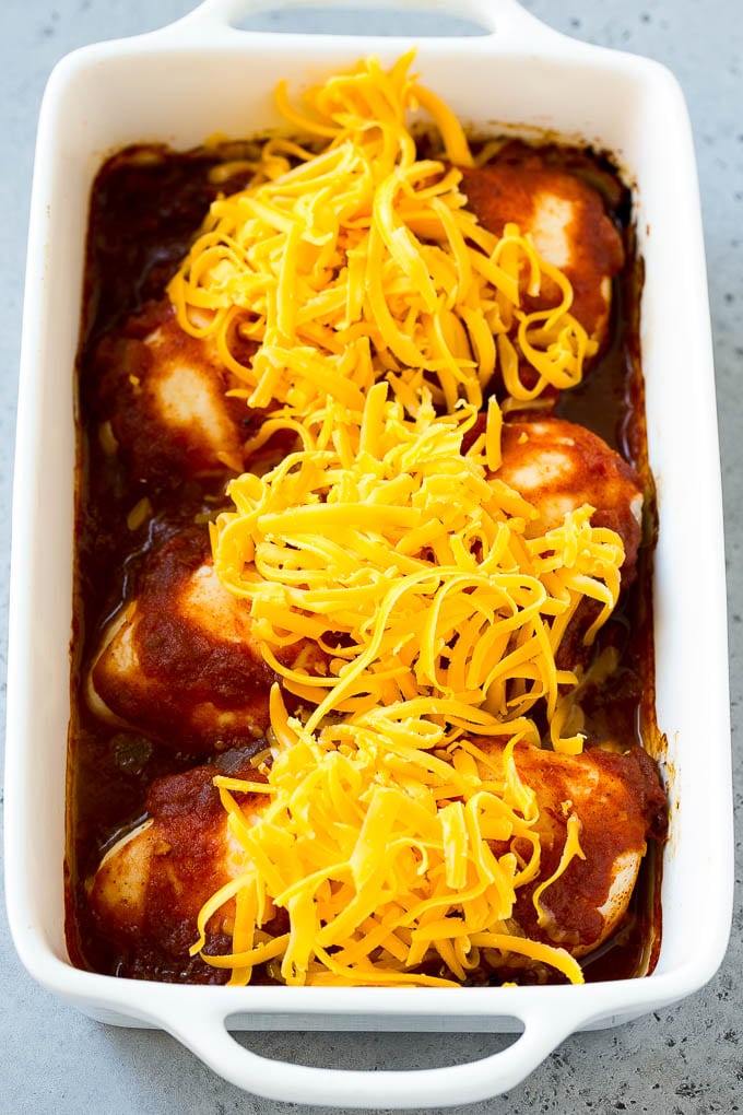 Chicken breasts coated in salsa and topped with shredded cheddar cheese.