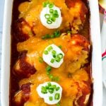 A dish of baked salsa chicken topped with cheese and sour cream.