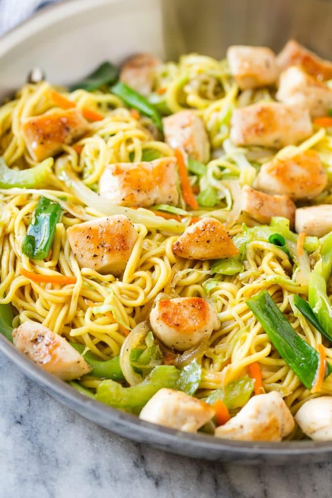 Chicken chow mein in a skillet with noodles and vegetables.