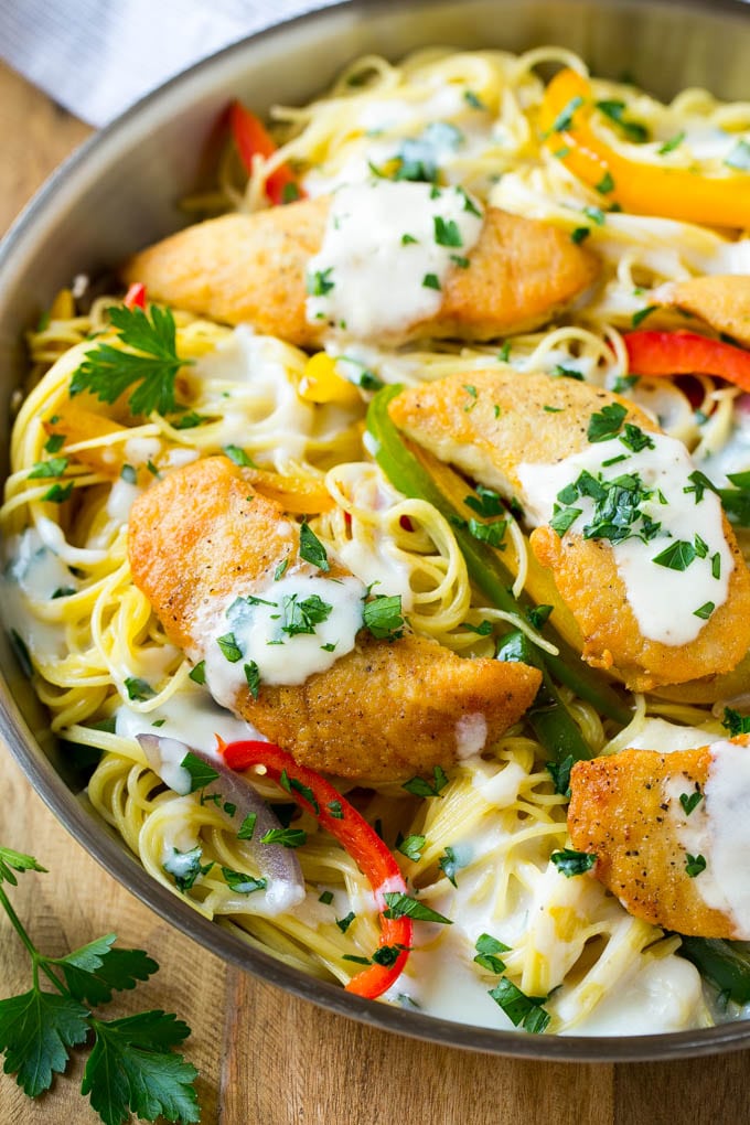 This chicken scampi is golden brown tenderloins with peppers and onions over creamy pasta. It's a restaurant favorite that tastes even better when you make it at home!