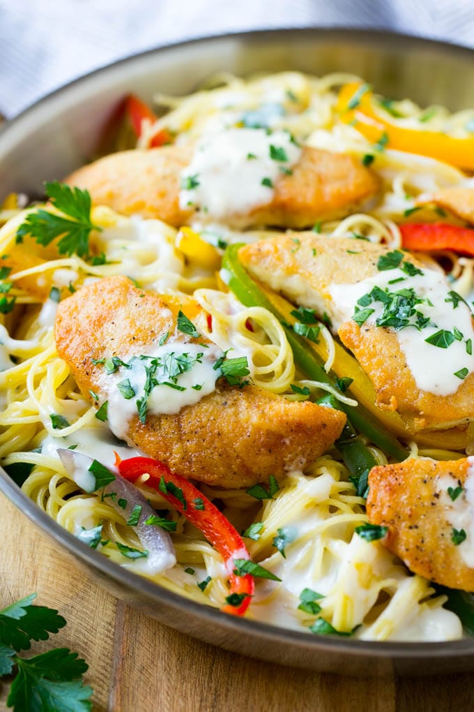 This chicken scampi is golden brown tenderloins with peppers and onions over creamy pasta. It's a restaurant favorite that tastes even better when you make it at home!