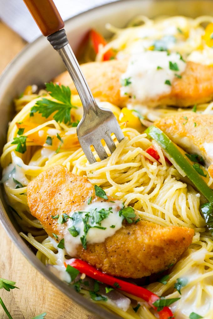 This chicken scampi is golden brown tenderloins with peppers and onions over creamy pasta. It's a restaurant favorite that tastes even better when you make it at home!