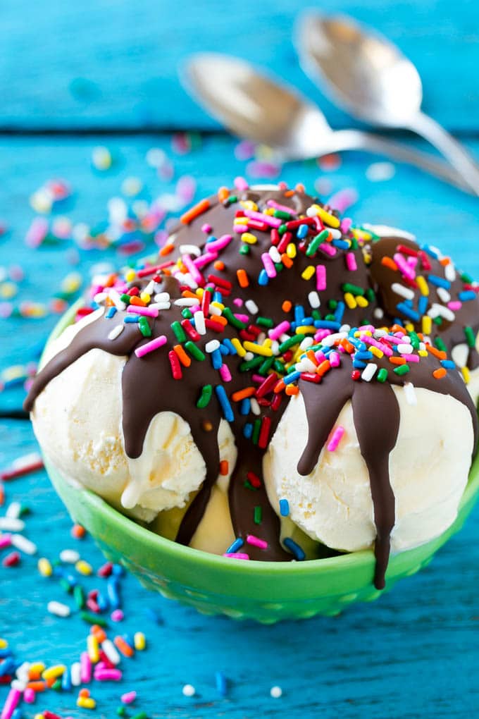 Magic shell over scoops of ice cream, topped with rainbow sprinkles.