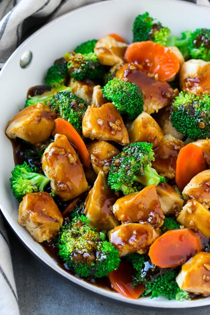 Chicken and vegetable stir fry in a pan, all coated with a garlic sauce.