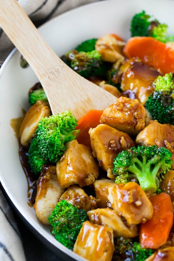 Honey garlic chicken stir fry with broccoli and carrots in a skillet.