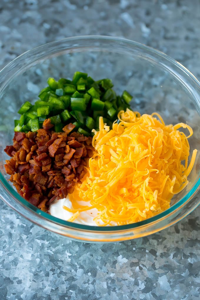 Cream cheese, sour cream, bacon, jalapenos and cheddar cheese in a mixing bowl.