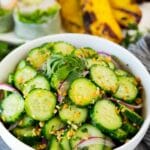 A bowl of Thai cucumber salad topped with peanuts and cilantro.
