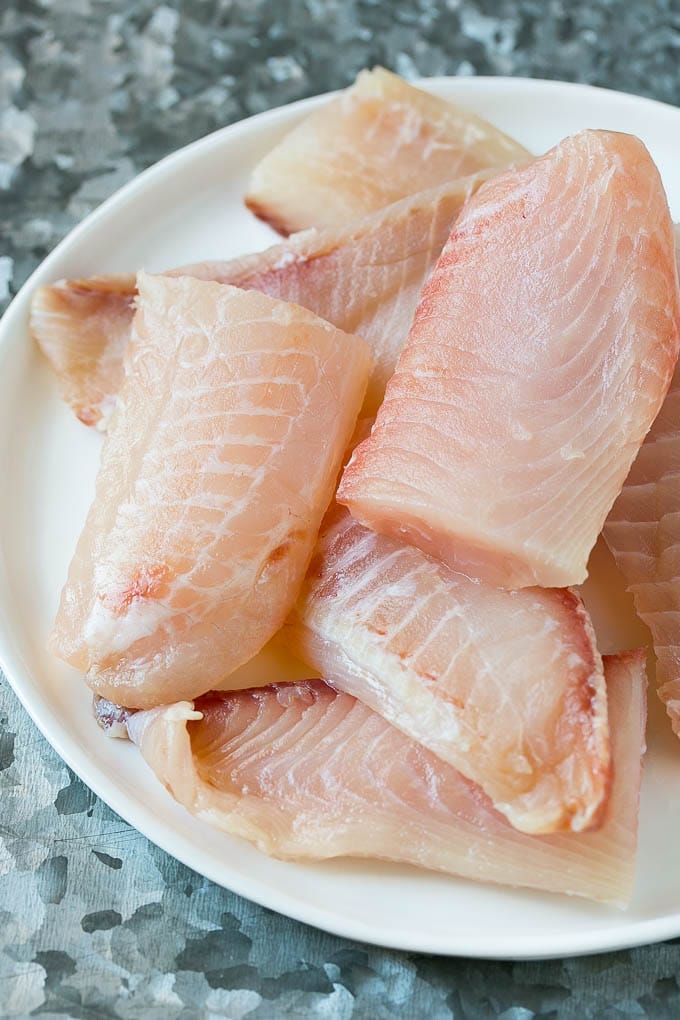 Tilapia fish fillets on a plate.