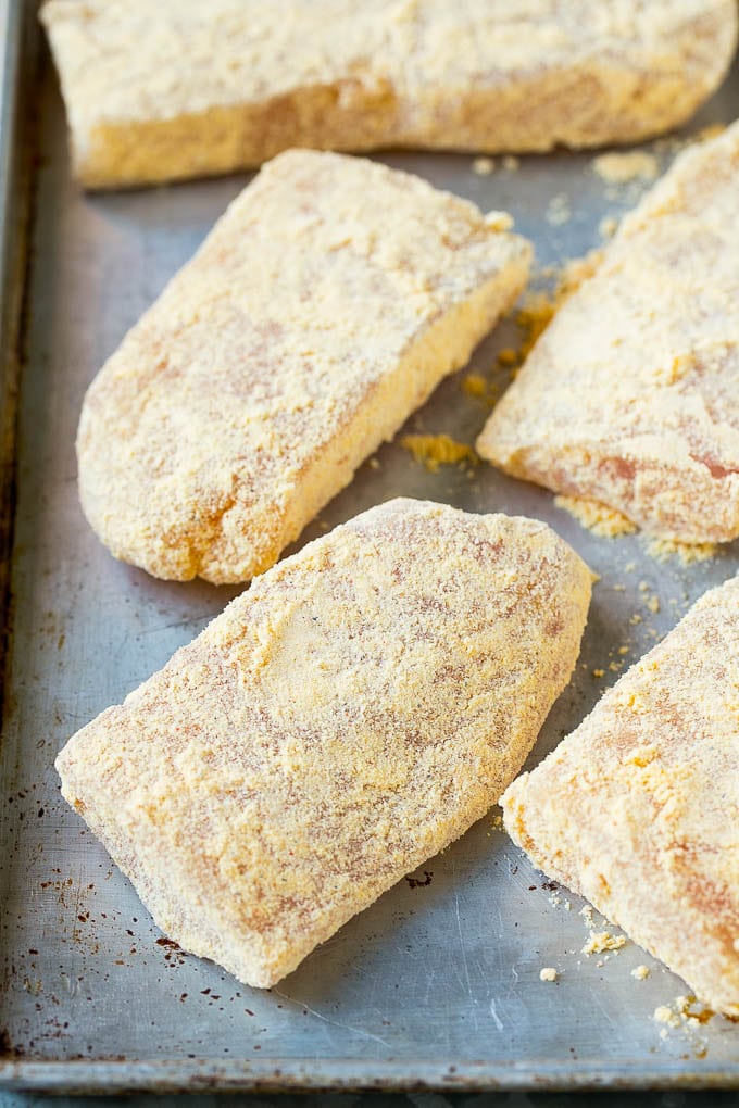 Breaded fish fillets on a sheet pan.