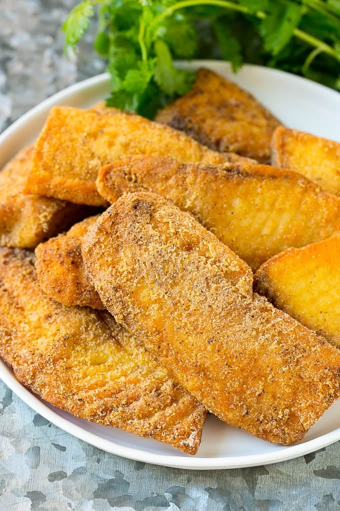 Fried and breaded fish fillets on a serving plate.