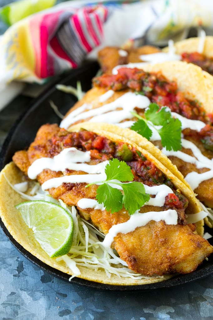 Baja fish tacos filled with crispy fish fillets and topped with salsa and white sauce.