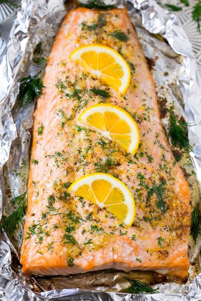 Salmon in foil topped with butter, garlic, dill and lemon slices.