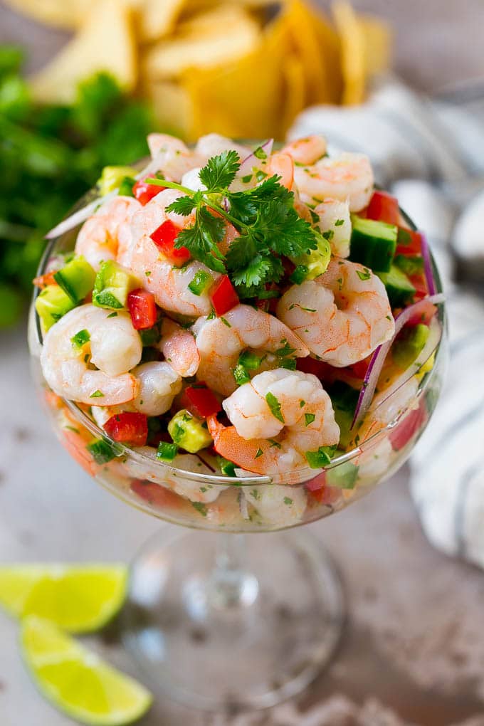 Shrimp ceviche in a serving cup garnished with cilantro.