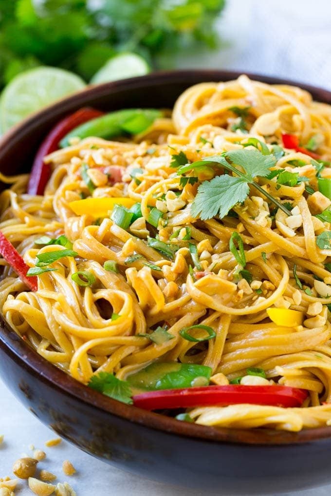 A bowl of Thai peanut noodles made with homemade peanut sauce, fresh vegetables and chopped peanuts.