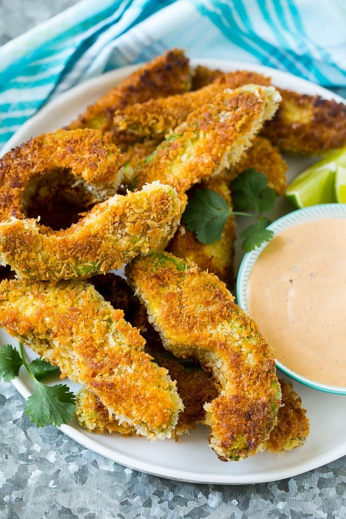 A plate of avocado fries served with dipping sauce.