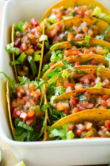 These oven baked beef tacos are filled with beans, meat and melted cheese, then topped off with shredded lettuce and fresh salsa. The best way to make tacos for a crowd!