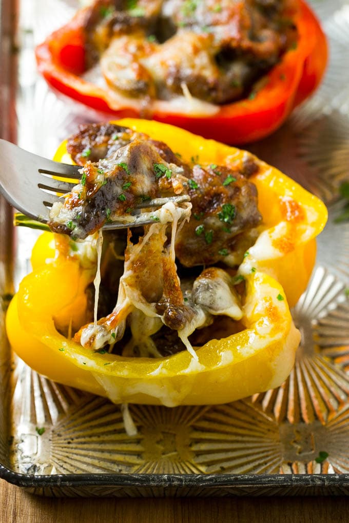 A fork pulling some steak out of a stuffed pepper.