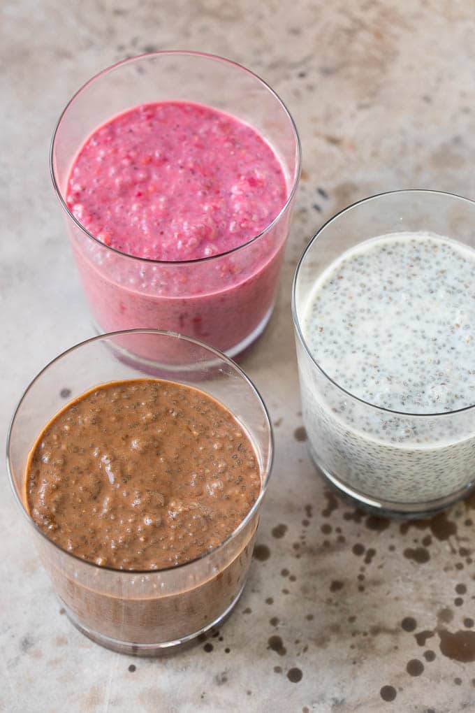 Cups of coconut chia pudding, raspberry chia pudding and chocolate chia pudding.