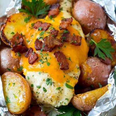 These bacon ranch chicken foil packets are a super easy dinner option with minimal cleanup! Chicken breasts are cooked with potatoes and ranch flavored butter, then topped with melted cheese and bacon for a meal that's sure to please any crowd.