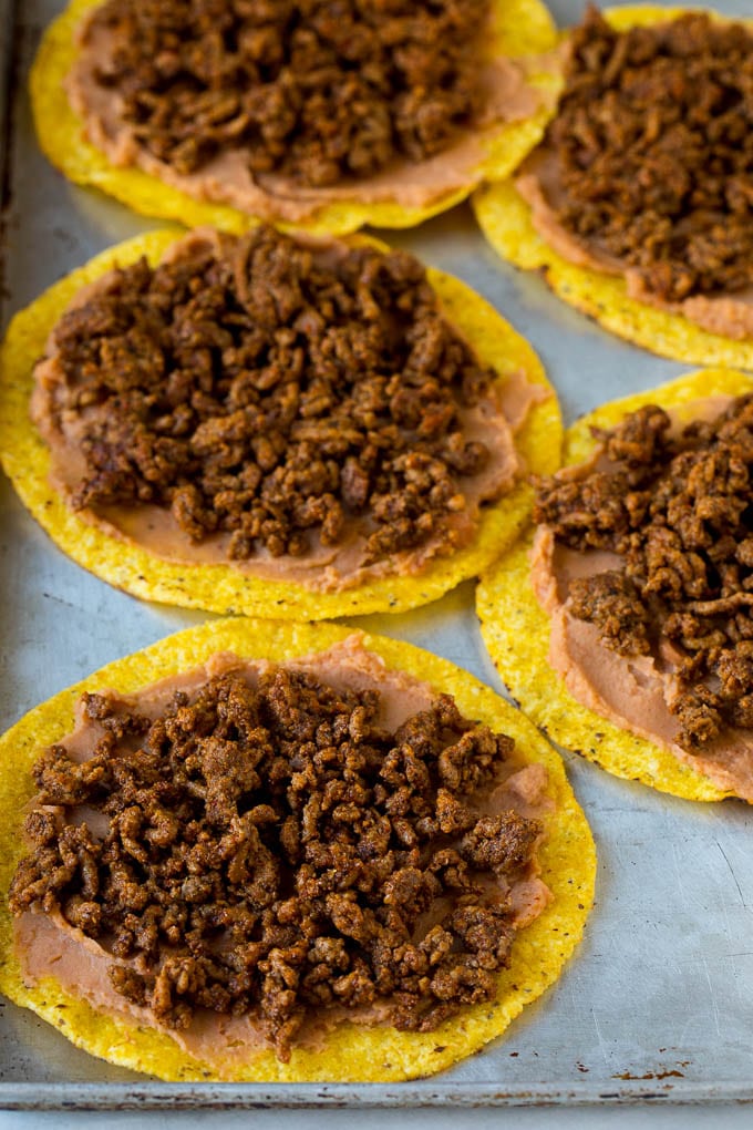 Tostada shells topped with refried beans and taco meat.