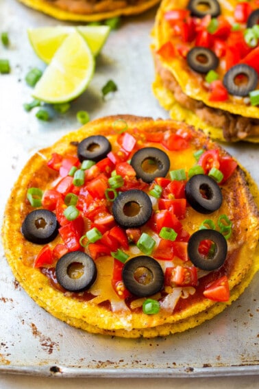 A Mexican pizza topped with cheese, tomatoes and olives.