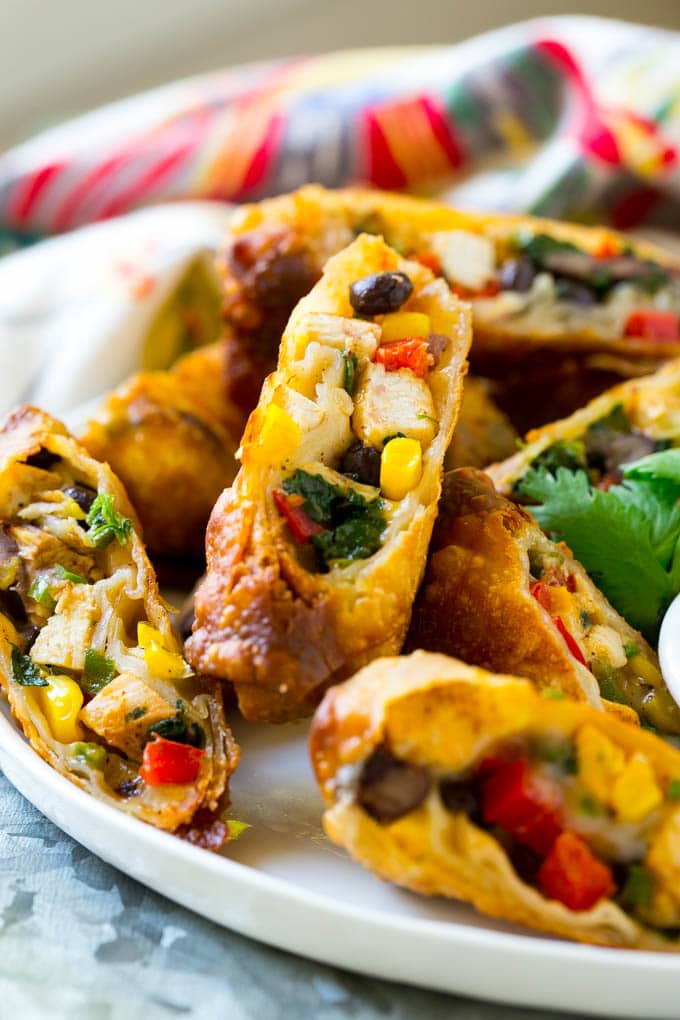 Chicken egg rolls with colorful vegetables, cut and served with avocado ranch sauce.