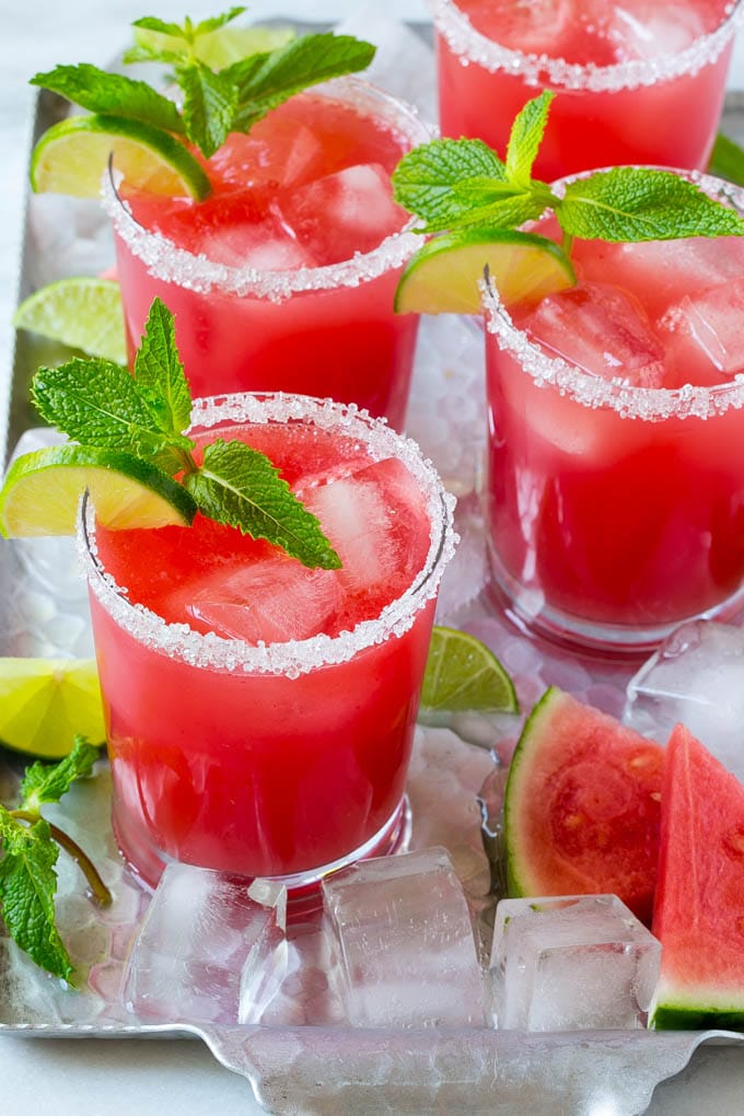 Watermelon agua fresca in sugar rimmed glasses with lime and mint for garnish.