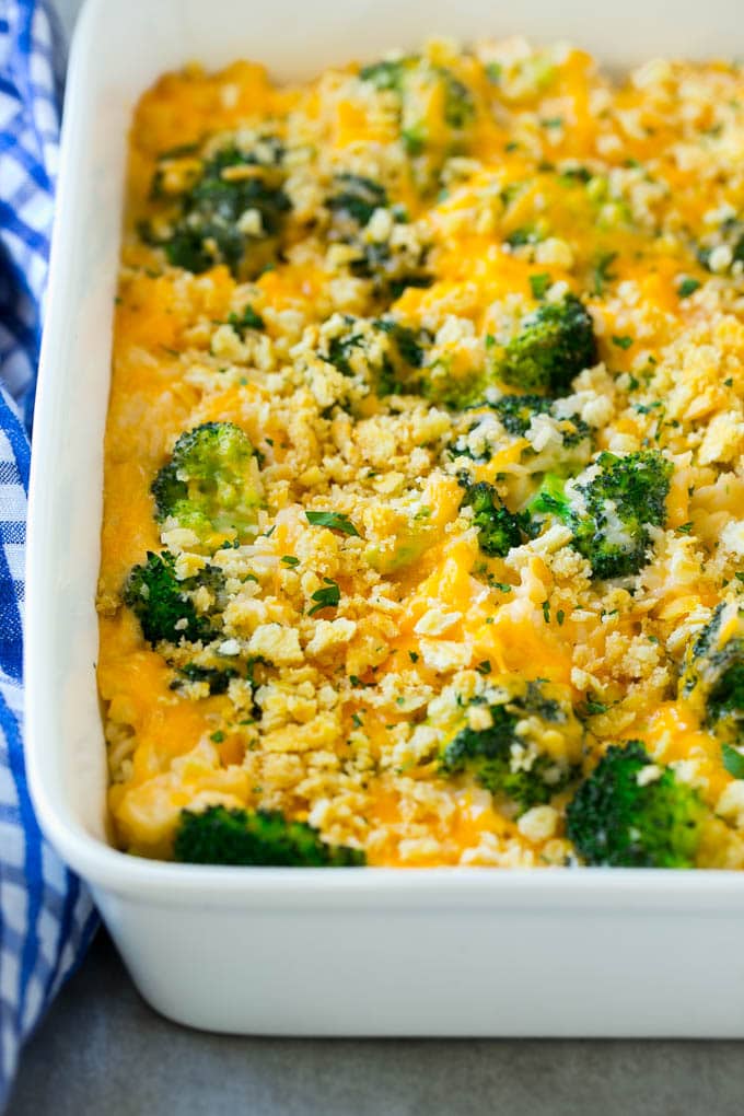 Broccoli and rice casserole with cheddar cheese in a white baking dish