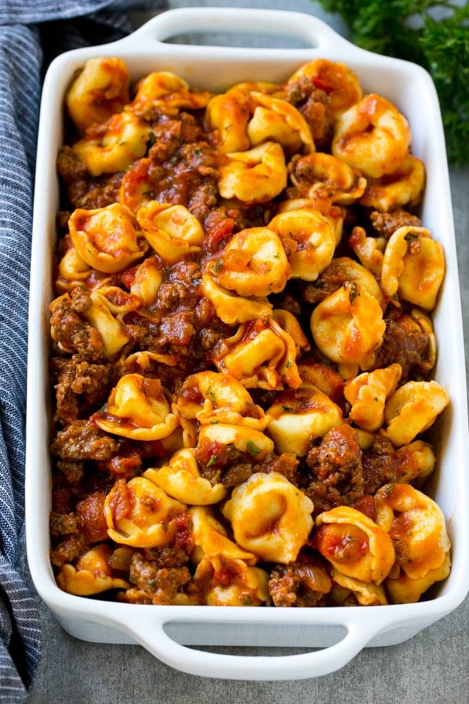 A dish of cheese tortellini tossed in meat sauce.