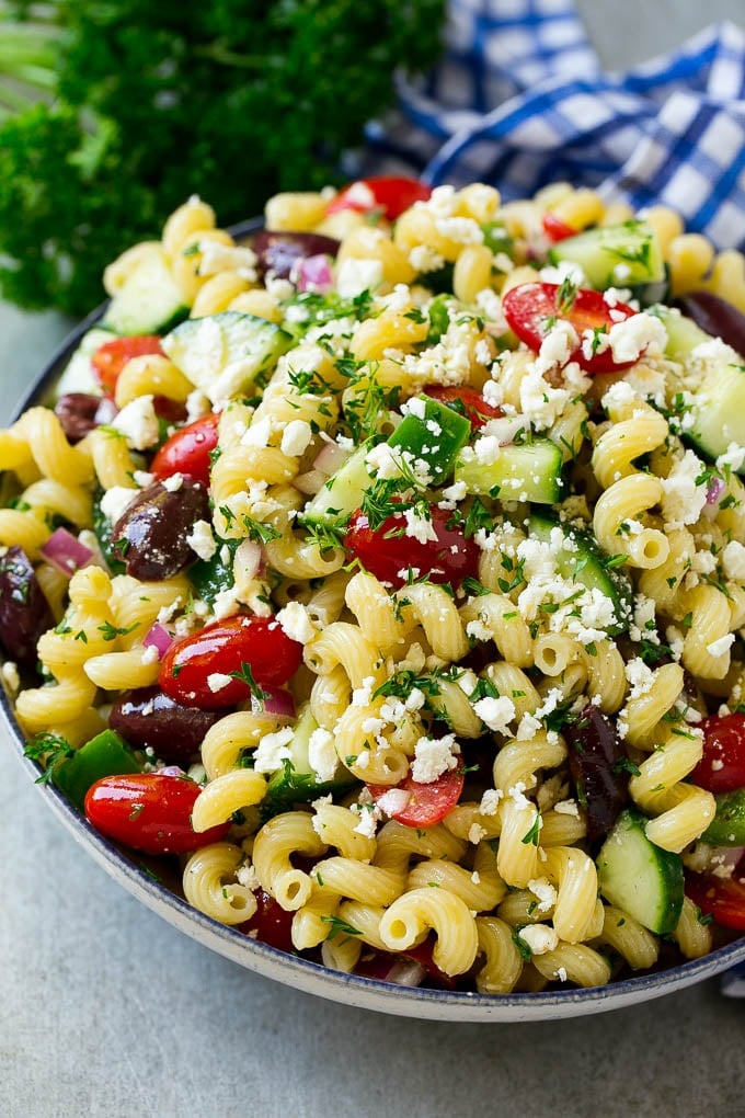 Greek pasta salad in a serving bowl, garnished with parsley.