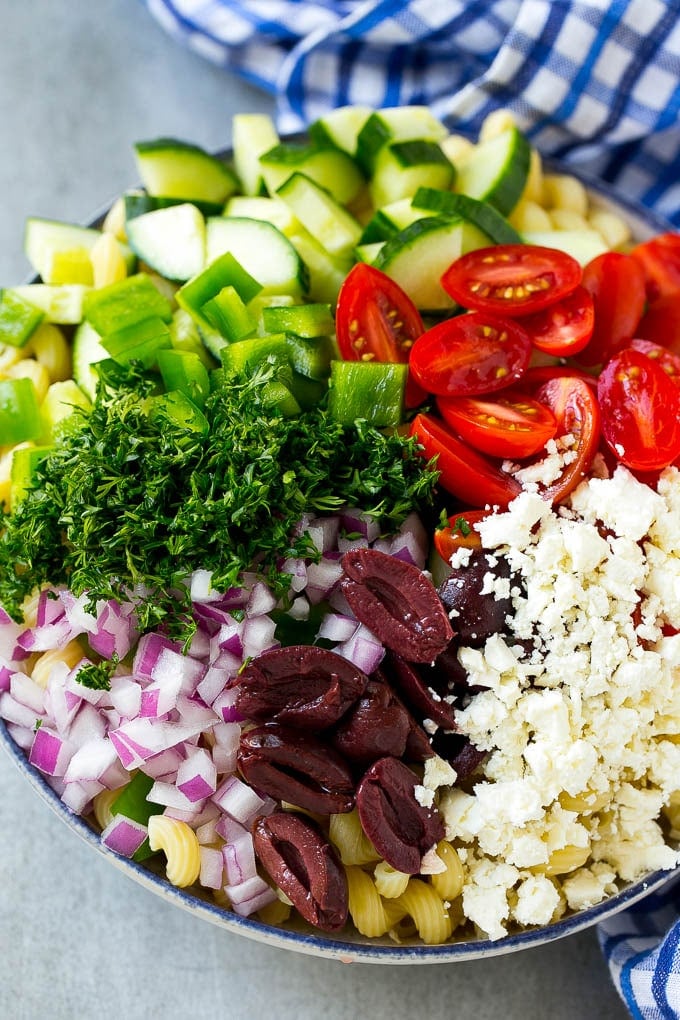 Cherry tomatoes, bell pepper, olives, feta, herbs and cucumbers over pasta.