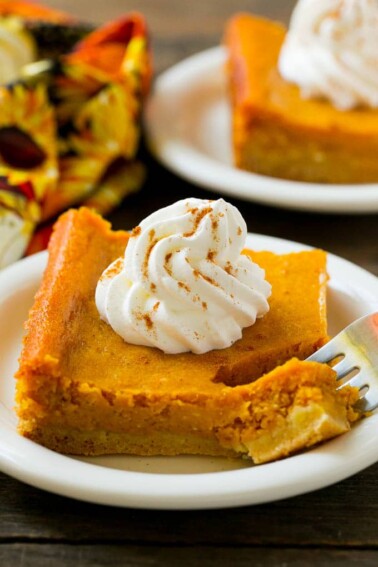 A piece of pumpkin gooey butter cake with a fork in it.