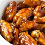 A slow cooker full of barbecue chicken wings.