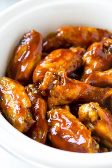 A slow cooker full of barbecue chicken wings.